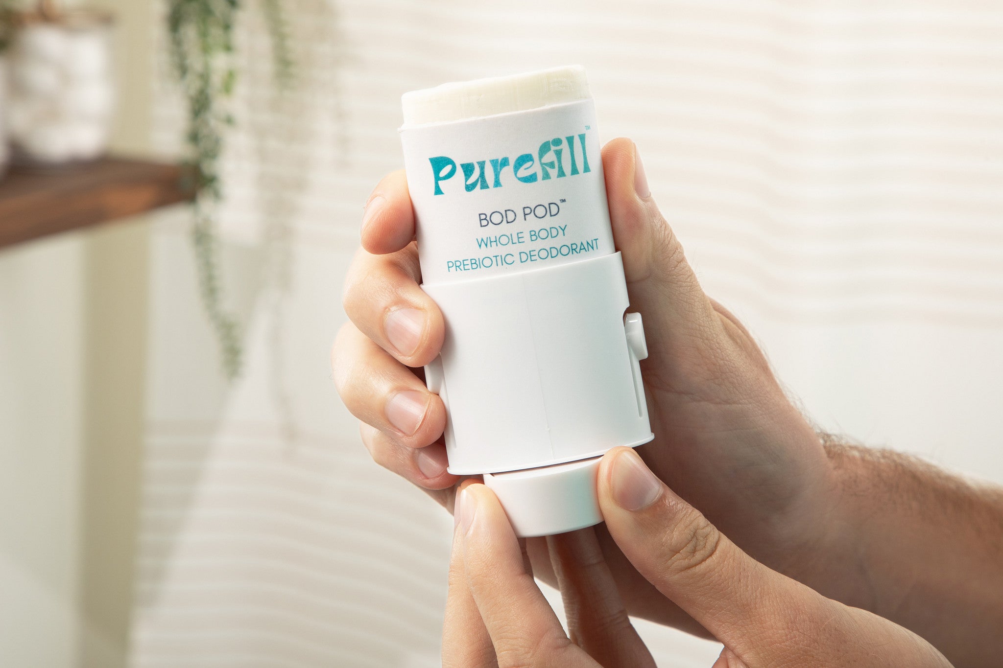 A person holding a Purefill whole body deodorant case