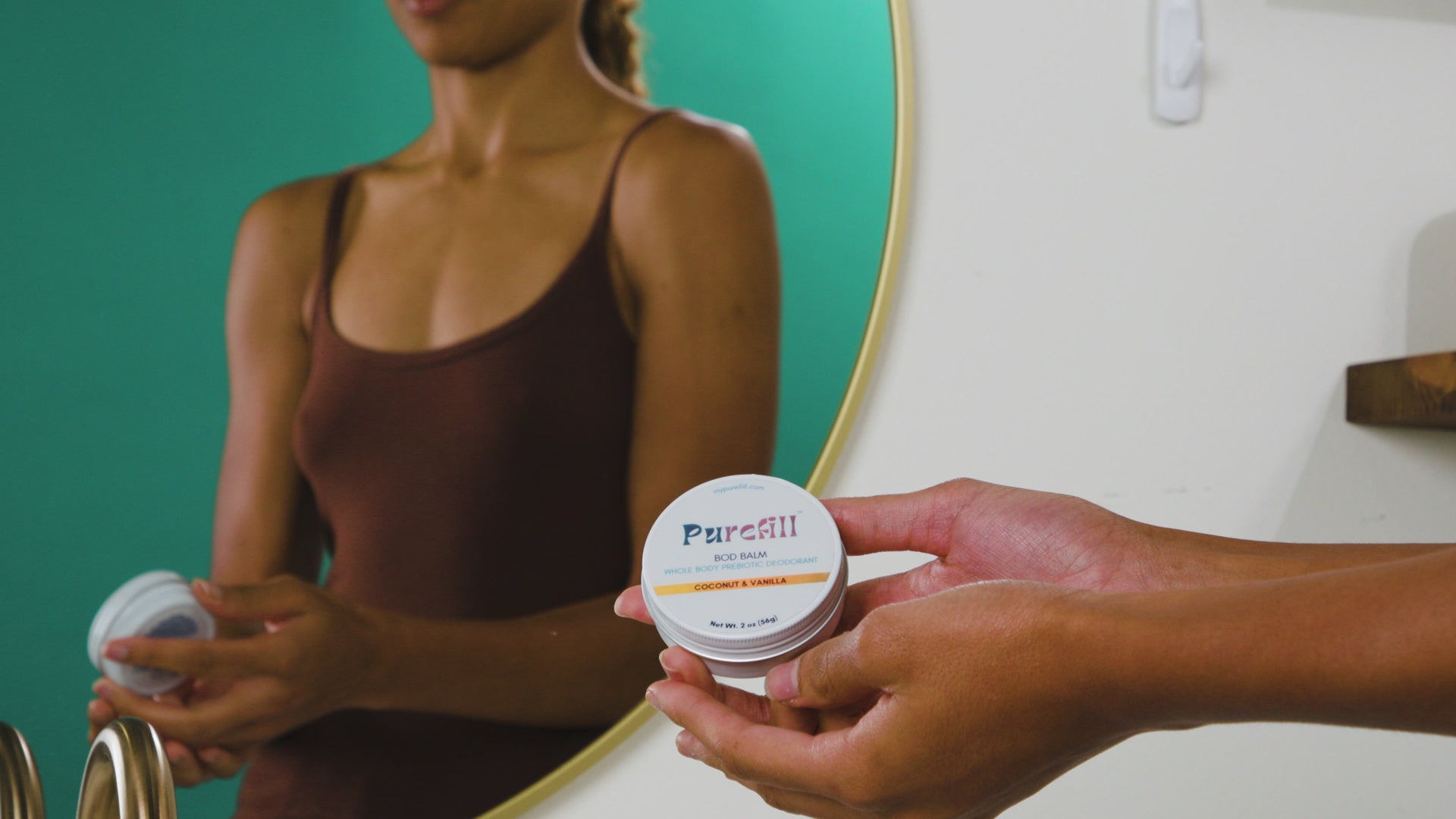 A woman using the Purefill Body Balm in Coconut and Vanilla in a bathroom on her chest